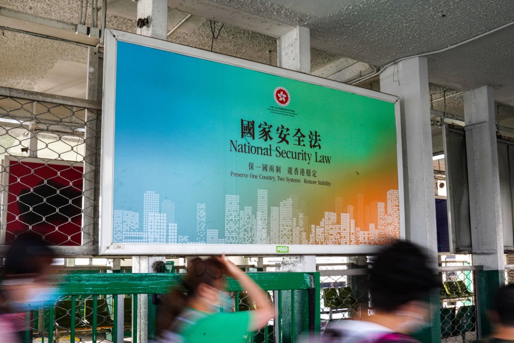 People walk past a large banner promoting the Hong Kong National Security Law at the Star Ferry Pier in Tsim Sha Tsui in June 2020. Photo: Sam Tsang