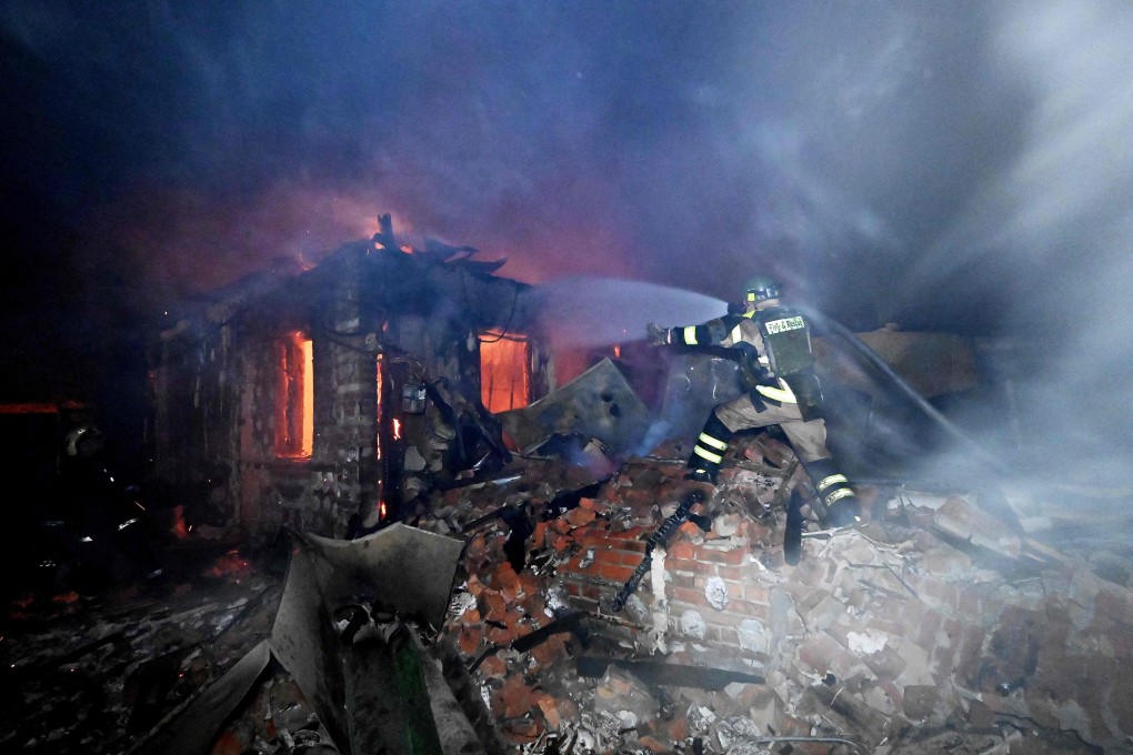 A Ukrainian rescuer works to extinguish a fire at the site of a drone attack in Kharkiv on Tuesday. Ukrainian officials hope that signing the deal promoted by US President Donald Trump will help to firm up softening American support for Kyiv. Photo: AFP