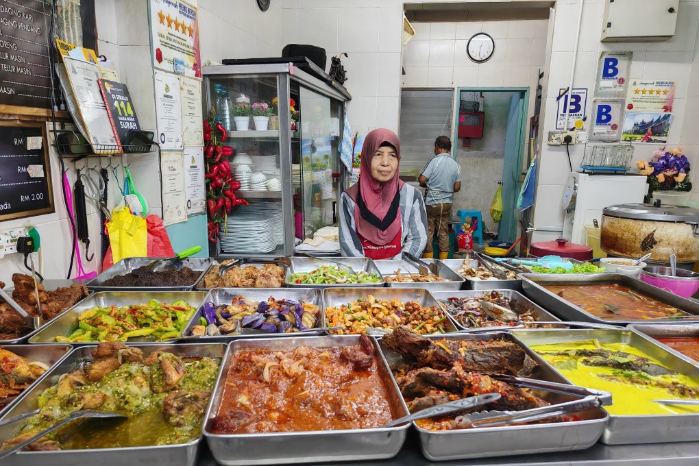 Rising cost of ingredients has forced Murni Adlis, 66, to raise the price of some of the dishes like beef rendang and fried chicken served at her nasi padang stall. Photo: Joseph Sipalan