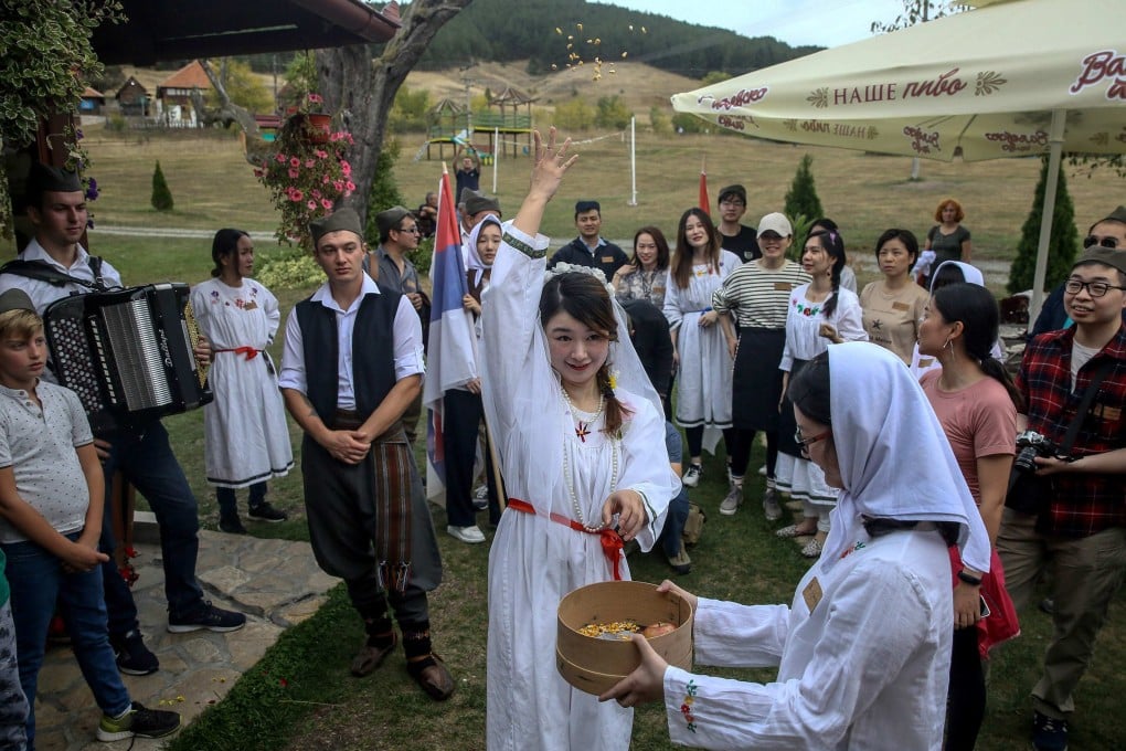 A Chinese tourist throws wheat while dressed up as a bride for a traditional Serbian wedding experience in Gostoljublje, a village near the Serbian town of Kosjeric, in 2019. The year before the pandemic hit, Chinese tourists topped the world in outbound spending. Photo: AFP