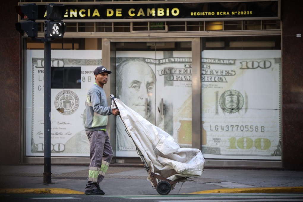 A man walks past a currency exchange office in Buenos Aires, Argentina, on April 1. While many expect the US dollar to keep depreciating, the currency still accounts for nearly 60 per cent of foreign reserve holdings and almost 90 per cent of foreign exchange transactions. Photo: EPA-EFE