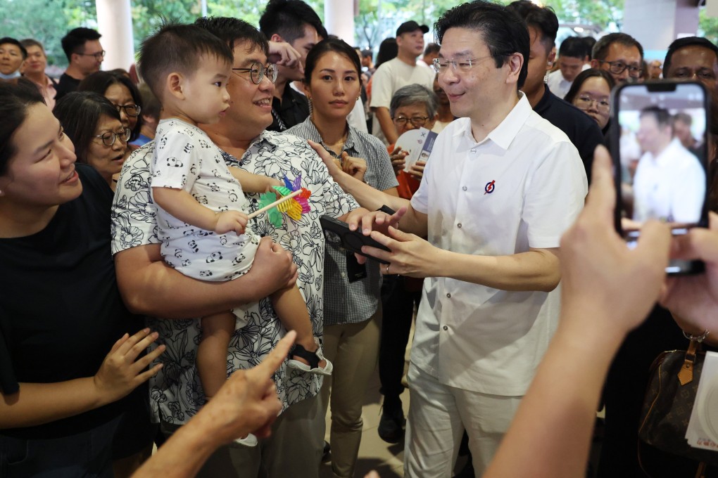 Singapore’s Prime Minister Lawrence Wong (right) greets residents during a campaign walkabout. Photo: EPA-EFE