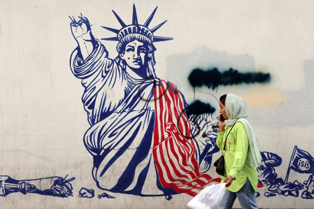 An Iranian woman walks past an anti-US mural near the former US embassy in a street in Tehran, Iran, on Thursday. Photo: EPA-EFE