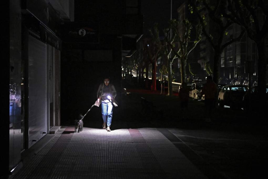 A woman walks her dog in Vigo, Spain. The country was among the European nations hit by a massive power cut on Monday. Photo: AFP/Getty Images/TNS