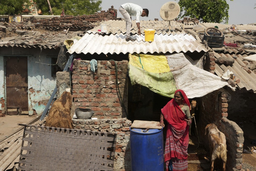 A man applies reflective paint on the roof of a house to reduce indoor heat in Ahmedabad, India, on April 2. Photo: AP