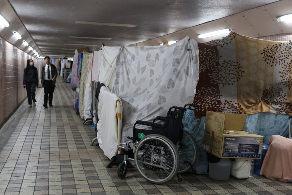 People walk past a few street sleepers’ makeshift dwellings in a subway tunnel in Happy Valley. Photo: Edmond So