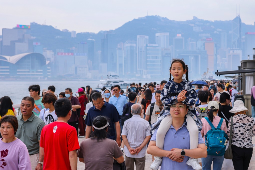Mainland tourists enjoy a walk at the harbourfront in Tsim Sha Tsui on the third day of the Labour Day “golden week” holiday. Photo: Nora Tam