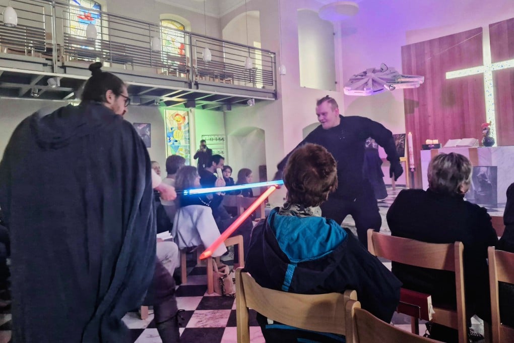 Pastor Samuel Dorr, left, performs a lightsaber duel with a member of the congregation during a Star Wars-themed church service in Bensberg, Germany on Sunday. Photo: dpa via AP