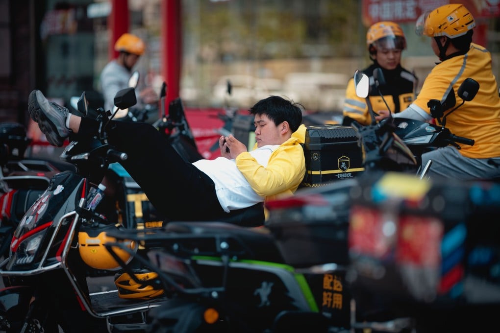 A delivery courier takes a brake on his scooter in Shanghai on April 28. Photo: EPA-EFE