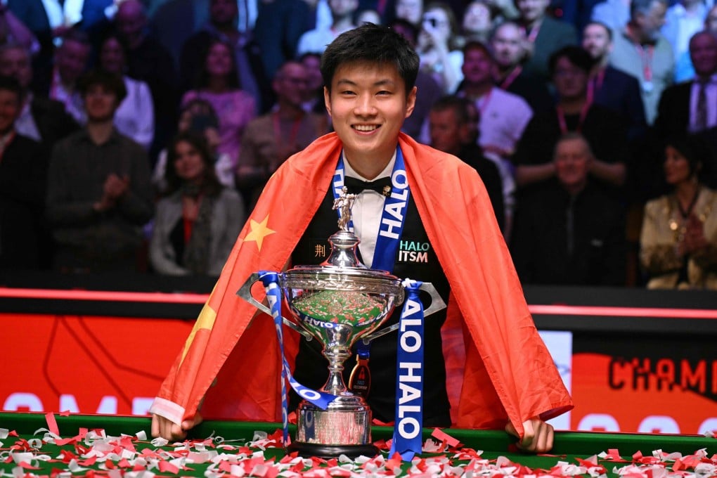 China’s Zhao Xintong poses with the world championship trophy after winning the final at the Crucible Theatre in Sheffield. Photo: AFP