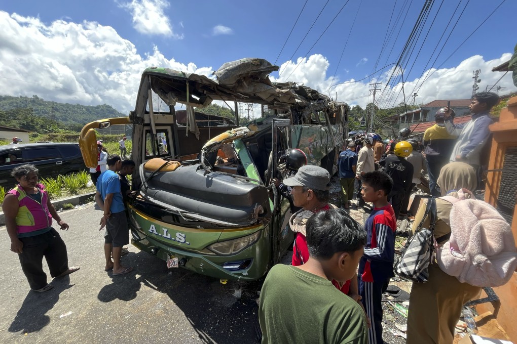 People inspect the wreckage of a passenger bus after it overturned in West Sumatra province, Indonesia, on Tuesday. Photo: AP