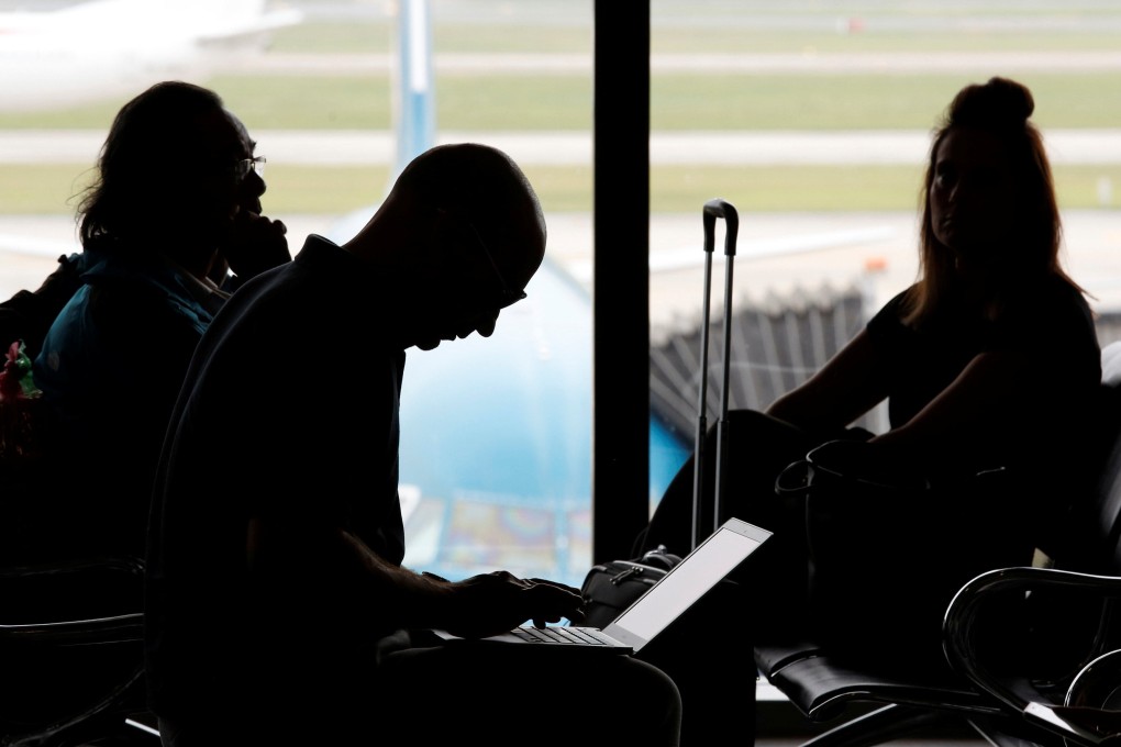 A man works on a laptop at an airport. To protect your data the Electronic Frontier Foundation, a non-profit organisation focused on civil rights in the digital age, recommends leaving behind laptops and other computers if you are travelling to the United States. Photo: Reuters