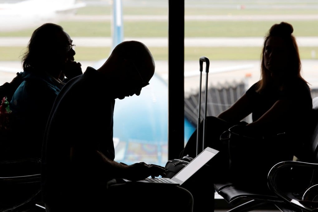 A man works on a laptop at an airport. To protect your data the Electronic Frontier Foundation, a non-profit organisation focused on civil rights in the digital age, recommends leaving behind laptops and other computers if you are travelling to the United States. Photo: Reuters