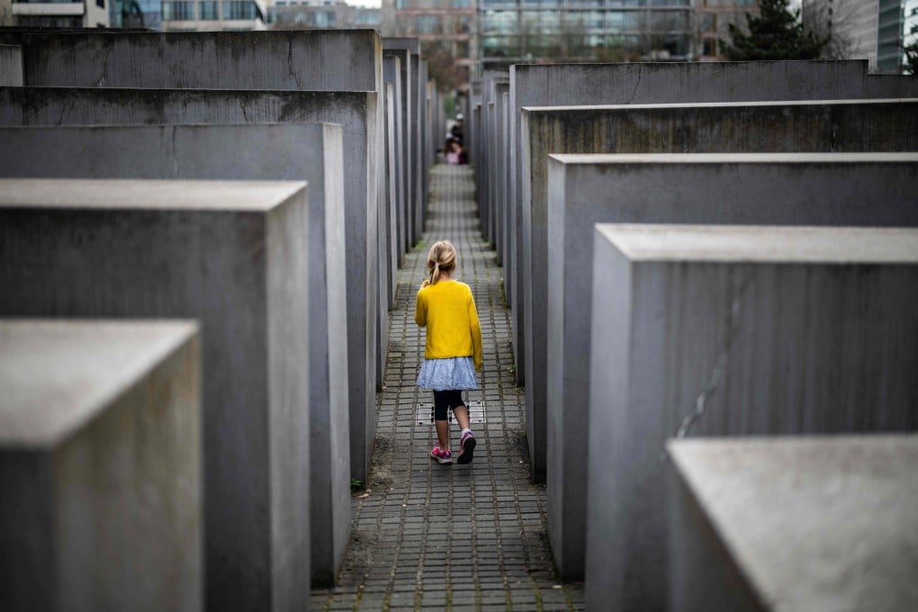 A young girl plays hide-and-seek among the concrete steles of the Holocaust memorial in Berlin on April 14, 2025. As the world readies to mark the 80th anniversary of the end of World War II, fears are growing that the country’s strong tradition of remembrance is starting to erode. Photo: AFP