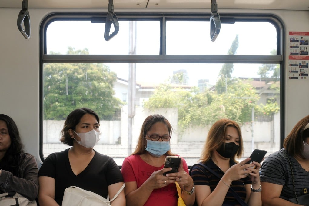 Filipinos look at their phones during their commute in an LRT train in Manila, the Philippines. Photo: Shutterstock
