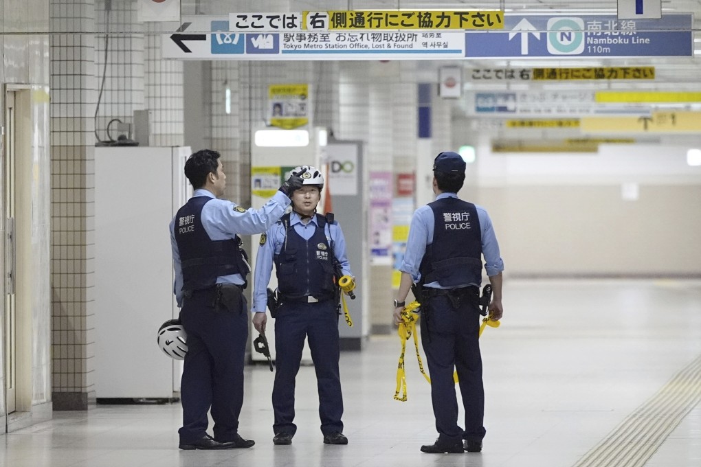 Police officers gather at Todaimae Station where two men were Injured after a knife attack on Wednesday. Photo: via AP