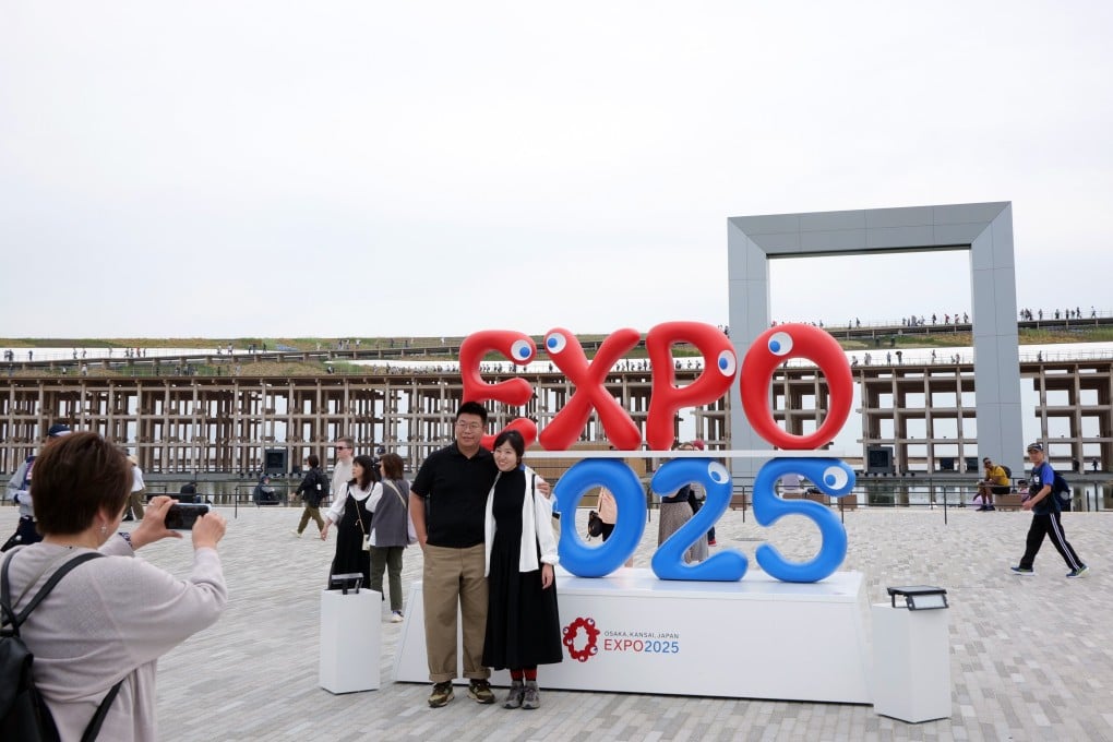 Visitors pose in front of a sign at the Osaka 2025 Expo in Osaka on April 22, 2025. Photo: EPA-EFE
