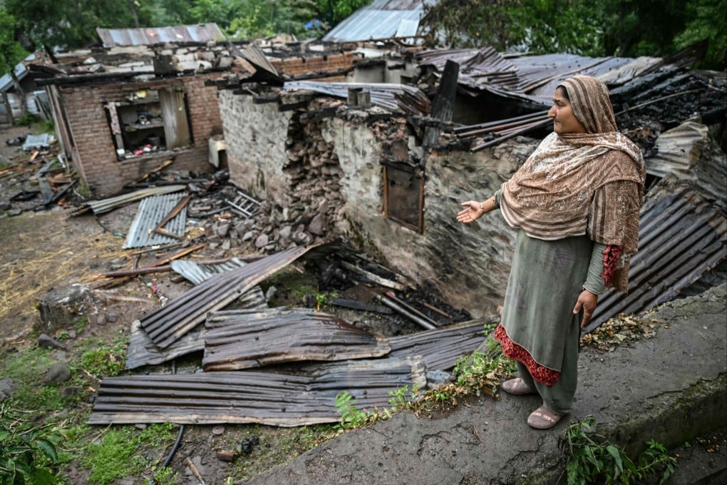 A woman stands outside her house destroyed by Pakistani shelling at a village in Uri, India-administered Kashmir, on May 8. Photo: AFP