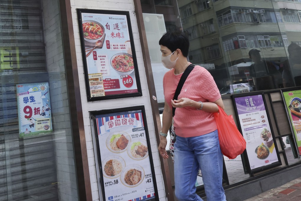 A  woman passes by a closed Ocean Empire congee shop in Wan Chai. Photo: Jelly Tse
