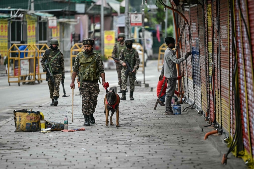 Indian paramilitary soldiers with a sniffer dog patrol at a marketplace in Srinagar on Saturday. Photo: AFP