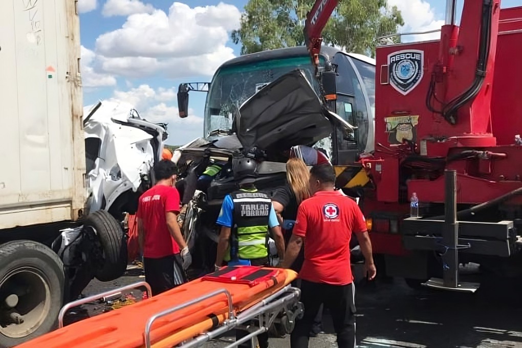 Rescuers inspect the site of a crash after a passenger bus slammed into a row of vehicles on a highway in Tarlac city, north of Manila, killing 10 people on May 1. Photo: Philippine Red Cross via AP