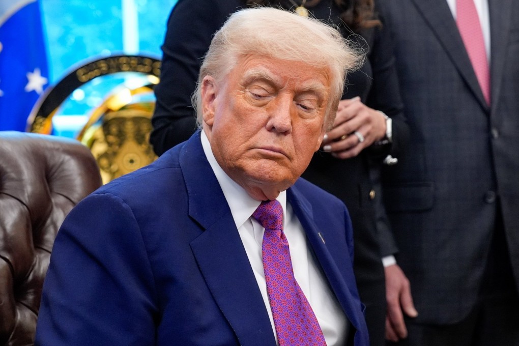 US President Donald Trump signs executive orders and speaks to reporters in the Oval Office on Friday. Photo: EPA-EFE