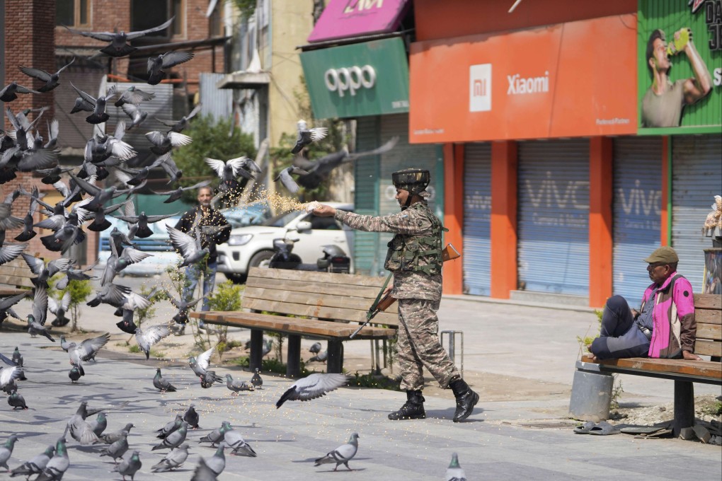 A soldier feeds pigeons at a market in Srinagar, Indian-controlled Kashmir, on Sunday. Photo: AP