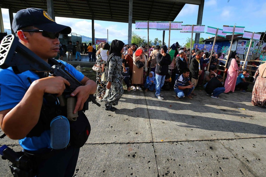 A policeman stands guard near a polling station during national midterm elections in Buadiposo town, Lanao del Sur province, on the southern island of Mindanao on Monday. Photo: AFP