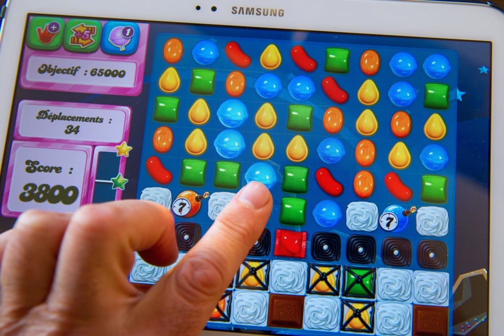 A person plays Candy Crush Saga on a tablet. Artificial intelligence is being used to help make the app more appealing to gamers. Photo: AFP