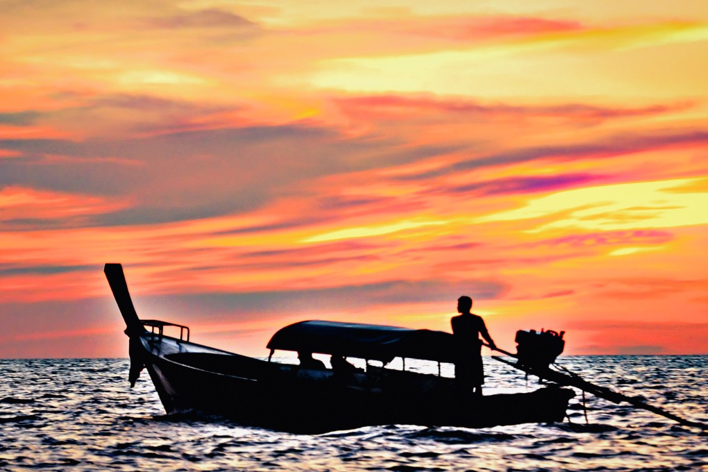 Koh Lipe Longboat travelling during sunset. Photo: Tim Pile