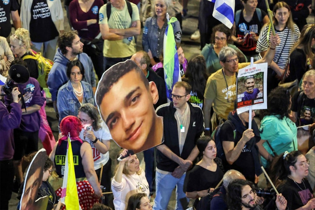 A demonstrator in Tel Aviv, Israel, holds a sign showing the face of Israeli-US hostage Edan Alexander. File photo: AFP