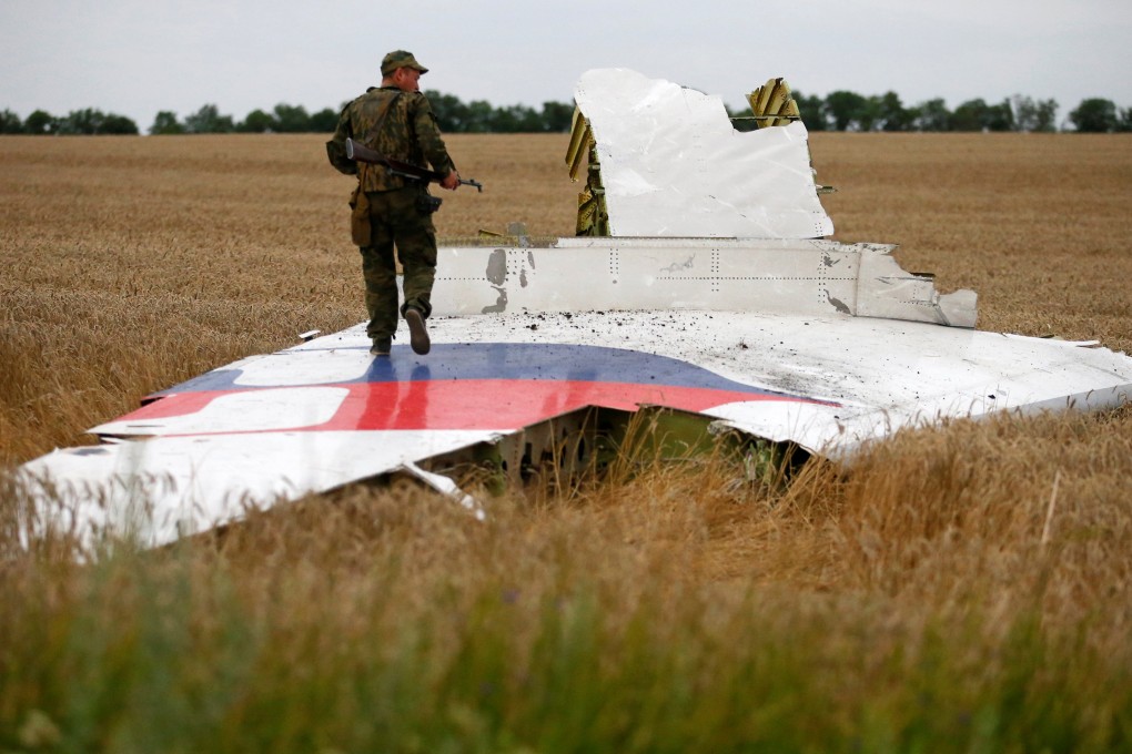 An armed pro-Russian separatist stands on part of the wreckage of Malaysia Airlines Flight MH17 after it crashed near the settlement of Grabovo in the Donetsk region of Ukraine on July 17, 2014. Photo: Reuters