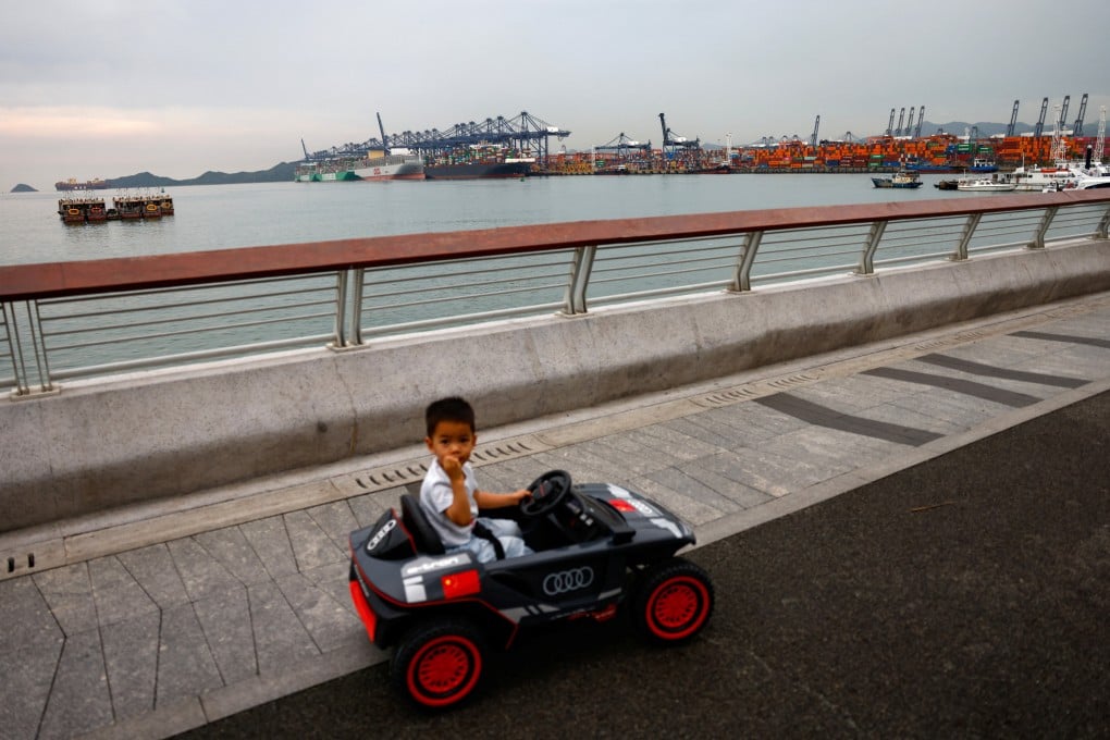 A child rides a toy car near Yantian port in Shenzhen, China, on May 9. If a made-in-China toy is to reach store shelves in the US before the holidays, the production process must begin as early as March, when toy companies finalise product designs and place orders. Photo: Reuters