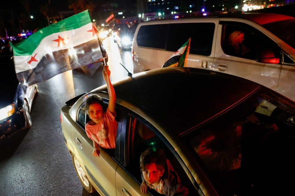 A girl holds a Syrian flag in Damascus, as people celebrate after US President Donald Trump said on Tuesday he would order the lifting of sanctions on Syria. Photo: Reuters