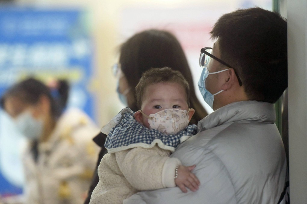 A baby wearing a face mask waits with family members in a hospital in Hangzhou, Zhejiang province, on January 6. Photo: AFP