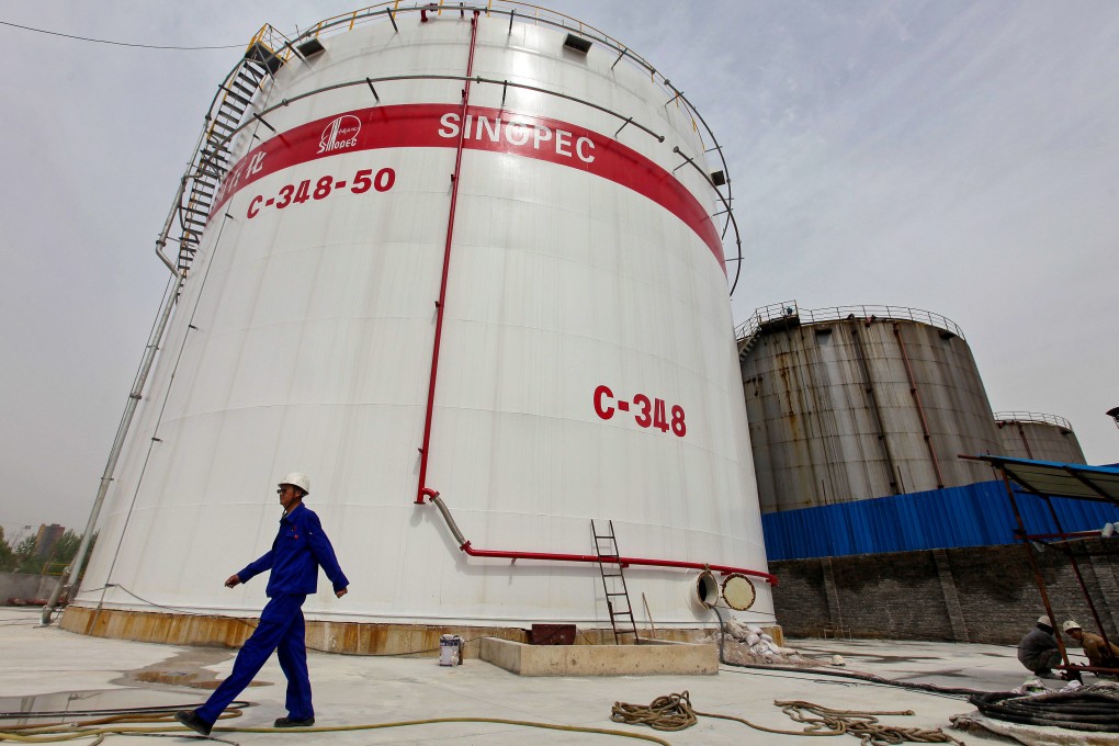 An employee passes tanks at a Sinopec refinery in Wuhan, Hubei province. Photo: Reuters