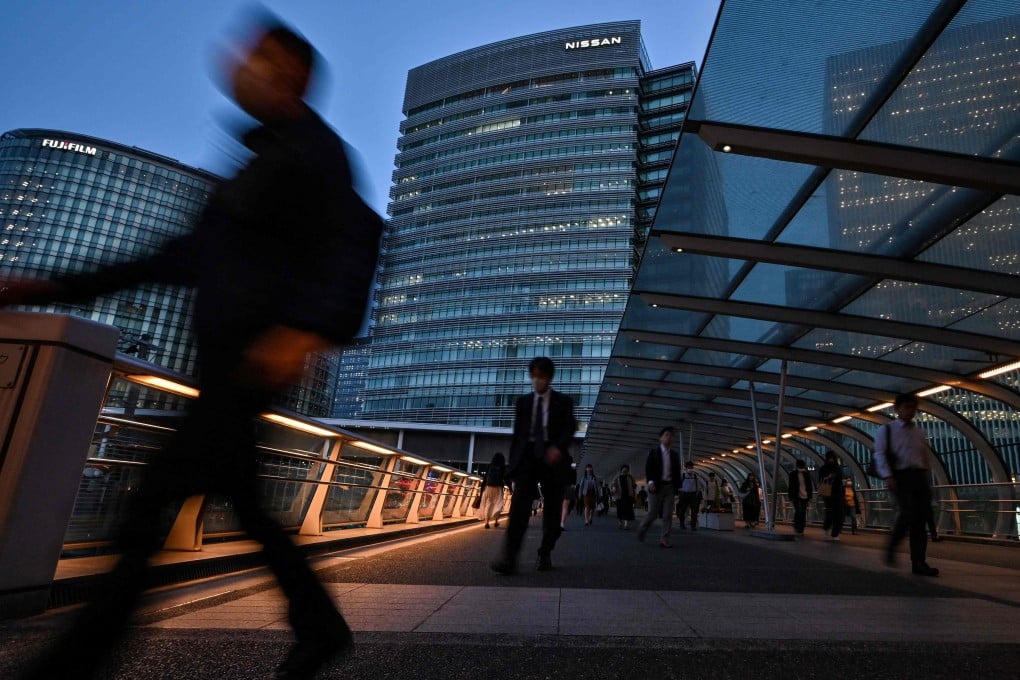 Pedestrians walk outside the headquarters of Japanese carmaker Nissan in Yokohama, Japan. Photo: AFP