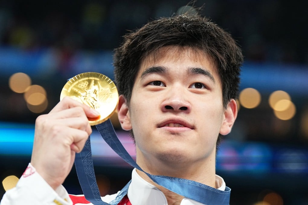China’s Pan Zhanle clutches his Olympic 100m freestyle gold medal at the Paris La Defence Arena last July. Photo: dpa