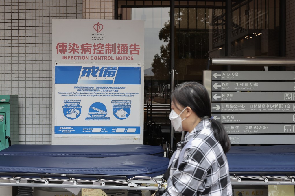 A woman walks past an infection control notice at Queen Elizabeth Hospital in Yau Ma Tei. Authorities earlier revealed the city recorded 75 severe adult cases of Covid-19 and 26 deaths in the past four weeks, exceeding the previous four-week period. Photo: Edmond So