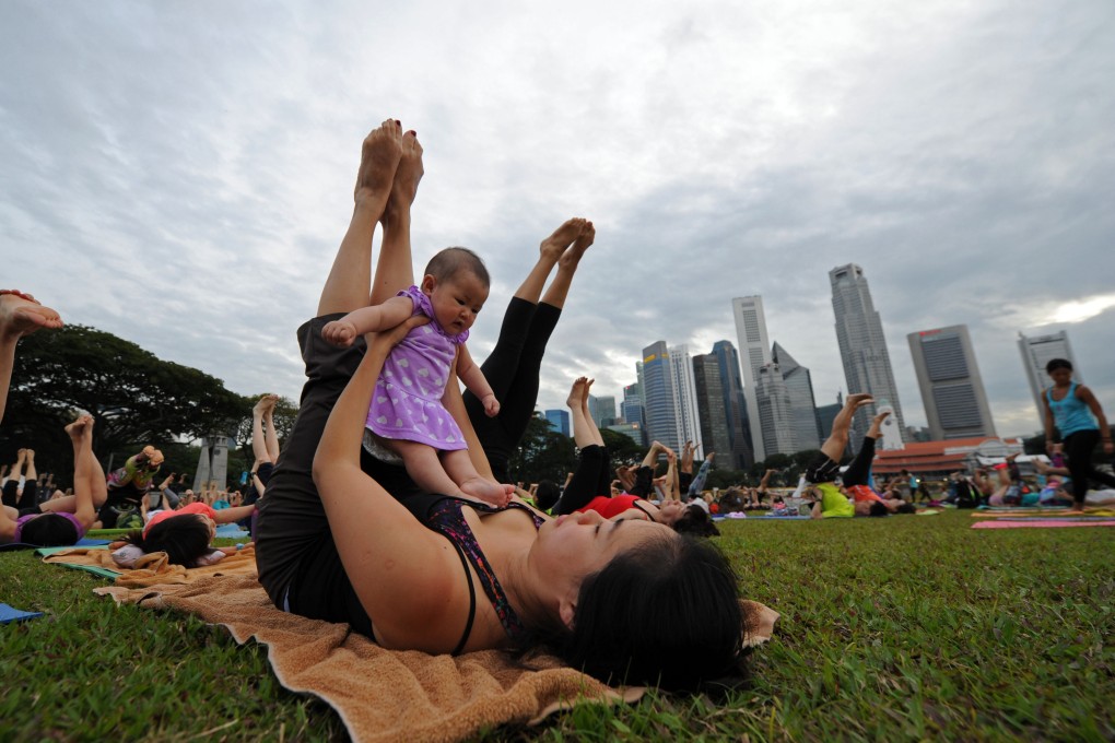 A woman with a child attends a New Year’s Eve countdown yoga session at Singapore’s Marina Bay in 2016. Photo: Xinhua