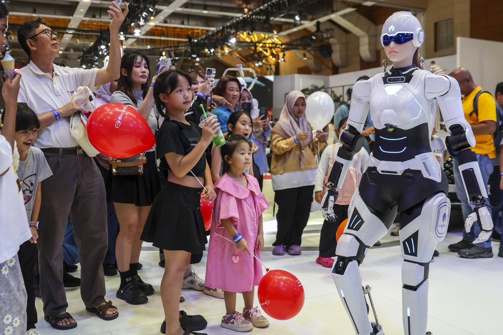 An AI robot sales assistant walks as visitors look on during the Malaysia Autoshow 2025 in Kuala Lumpur on May 10. Photo: EPA-EFE