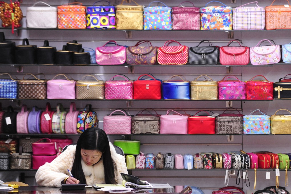 A trader works at a stall selling handbags inside the world’s largest wholesale market for small commodities in Yiwu, Zhejiang province. Small traders in China have been hit hard by US tariffs since April. Photo: AFP