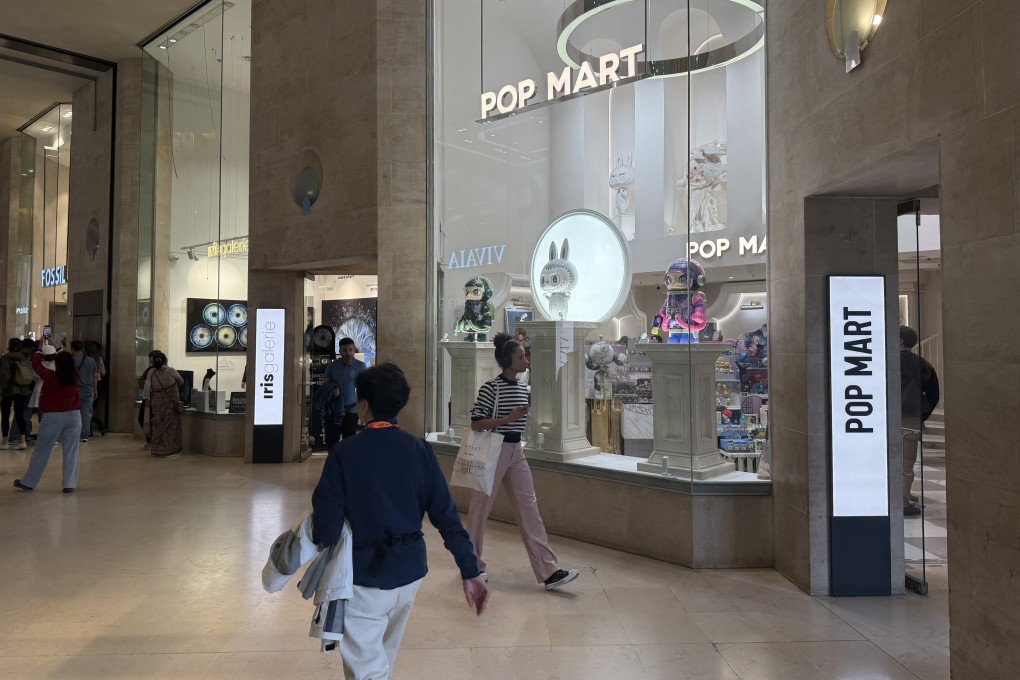 Shoppers walk past a Pop Mart store near the Louvre Museum in Paris. Chinese toy giant Pop Mart has gained a devoted following in Europe with its Labubu and Crybaby dolls.