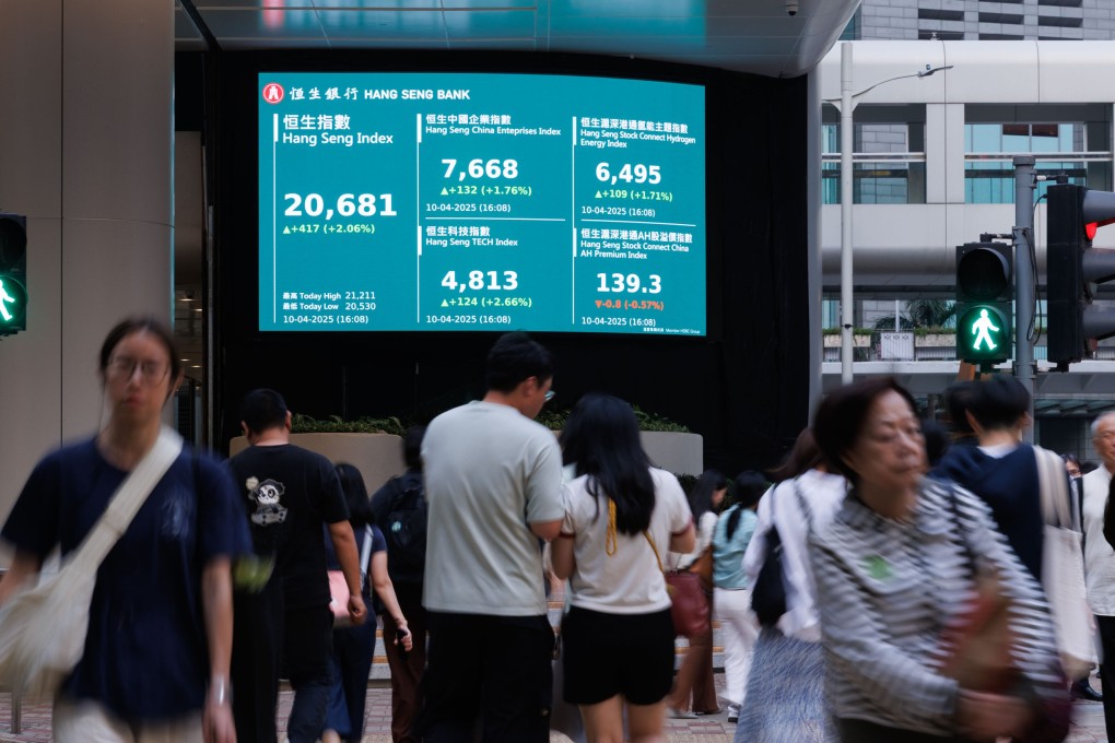 People walk past an electronic board showing major Hang Seng indices in Central, Hong Kong on April 10, 2025. Photo: dpa