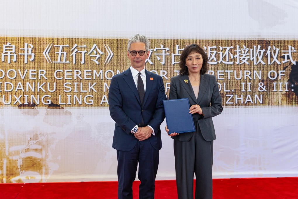 Zhu Ye (right) of the National Cultural Heritage Administration of China receives a certificate of transfer from Chase Robinson (left), director of the Smithsonian’s National Museum of Asian Art, during a handover ceremony for the Zidanku Silk Manuscripts in Washington on Friday. Photo: Xinhua