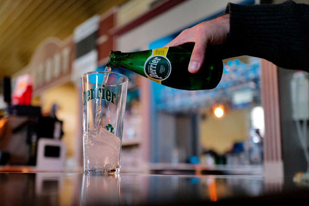 A man serves Perrier into a glass. The French government “at the highest level” covered up a scandal over the treatment of mineral water by food giant Nestle, including the iconic Perrier brand, a Senate investigation said on May Monday. Photo: AFP