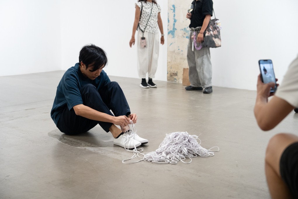 Artist South Ho is filmed as he knots a 100-metre-long shoelace prior to staging his performance artwork Me, My White Sneakers, and Shoelaces at Blindspot Gallery in Hong Kong. Photo: Ray Leung courtesy of artist and Blindspot Gallery