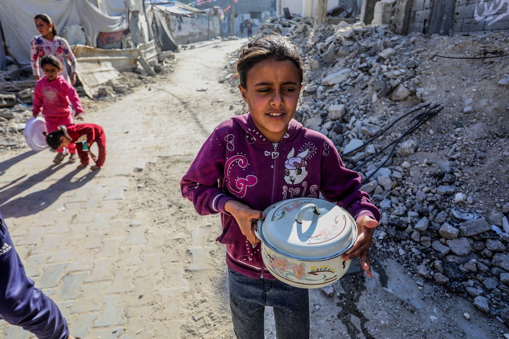 A Palestinian girl receives food aid in Khan Younis on Sunday. Israel plans to resume the delivery of basic humanitarian aid to Gaza, the prime minister’s office said on Sunday. Photo: dpa