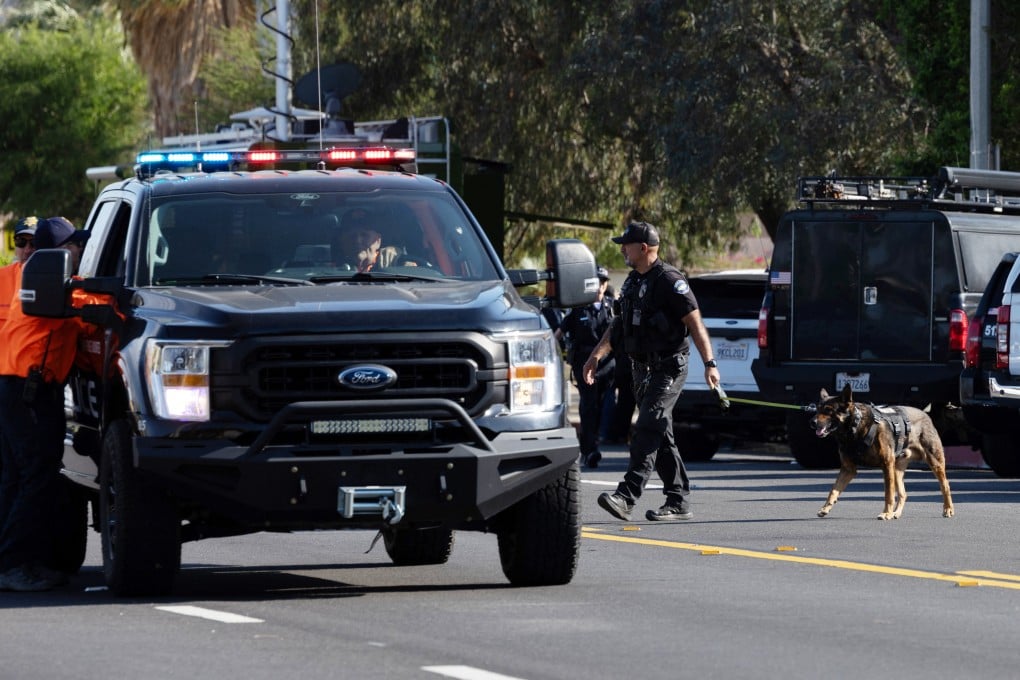 A police officer leads his dog to the scene after a bomb exploded near an IVF clinic in Palm Springs, California on Saturday. Photo: Reuters