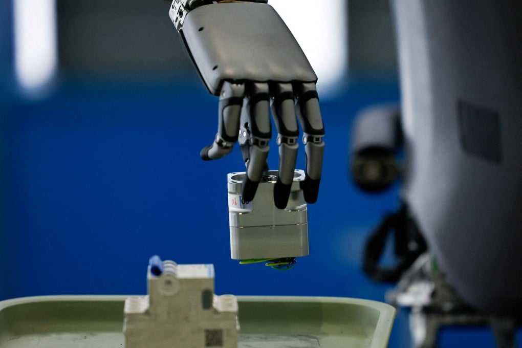 A UBTech humanoid robot picks up an object during a demonstration simulating a factory’s assembly line. Photo: Reuters